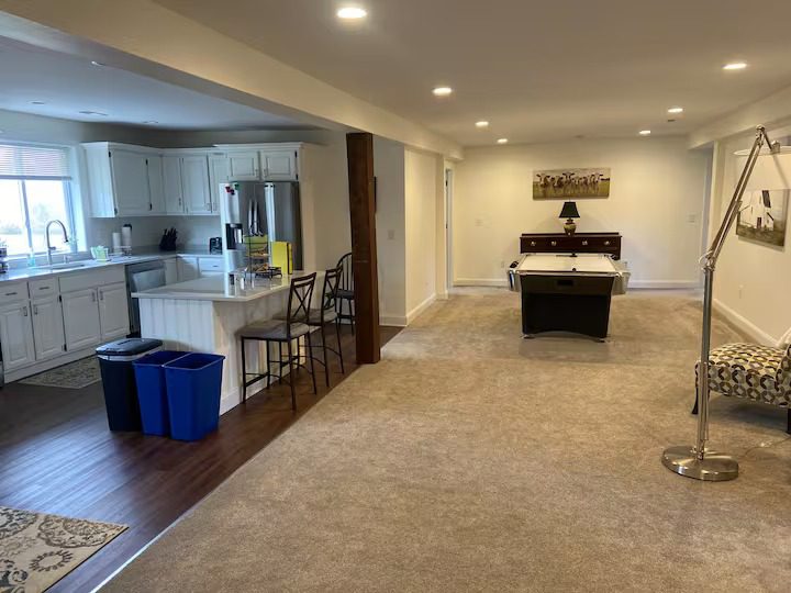 Spacious basement with kitchen and pool table.